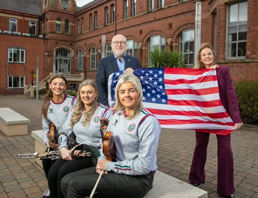 St Mary’s students Molly Walls, Maeve O’Donnell and Rosie McElroy, pictured with Belfast Lord Mayor, Christina Black and College Principal, Professor Peter Finn both holding on to an american flag