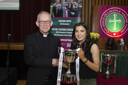 Fr Paul Fleming and Aine McAllister with the Moynihan Cup won by the Ladies Gaelic Football team in March 2018