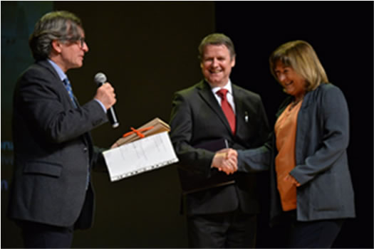 Dr Eibhlín Mhic Aoidh receives the award from Professor Grzegorz Władysław Przebinda, 