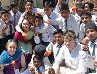 Sarah Hillis of Stranmillis and Maria McLarnon and Ryan Farrell of St Mary’s with the pupils of Sneha