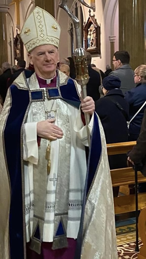 Archbishop Noel Treanor in his traditional dress of Mitre (head dress), Alb (inner garment) and Chasuble (outer cape) and walking down the central aisle of St Peter's Cathedral in Belfast.